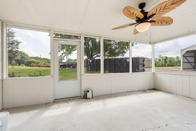 unfurnished sunroom featuring wood ceiling and ceiling fan