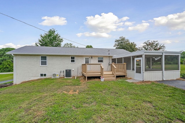 back of property featuring a yard, a sunroom, a deck, and central AC unit