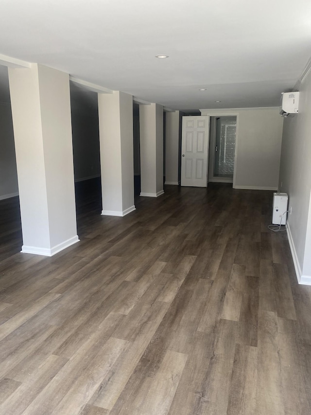 interior space with dark hardwood / wood-style flooring and a wall mounted air conditioner