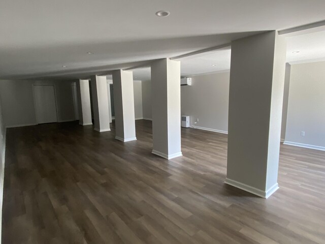 interior space featuring radiator heating unit, crown molding, hardwood / wood-style flooring, and an AC wall unit