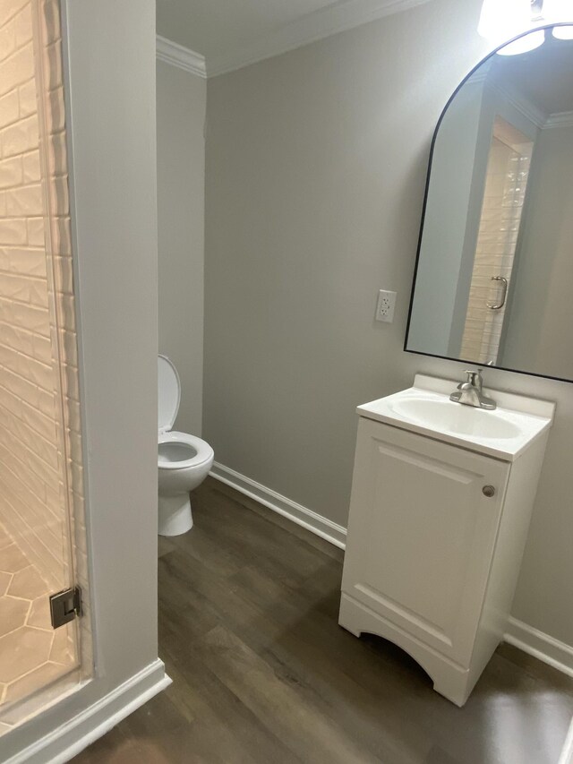 bathroom featuring vanity, ornamental molding, toilet, and hardwood / wood-style floors