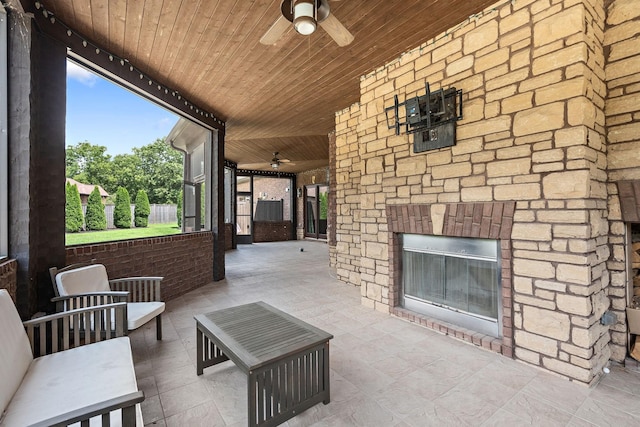 view of patio / terrace with an outdoor living space with a fireplace and ceiling fan