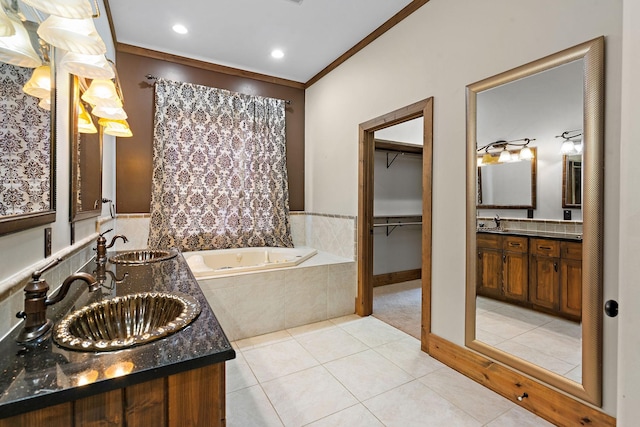 bathroom featuring tile patterned flooring, vanity, ornamental molding, and tiled tub