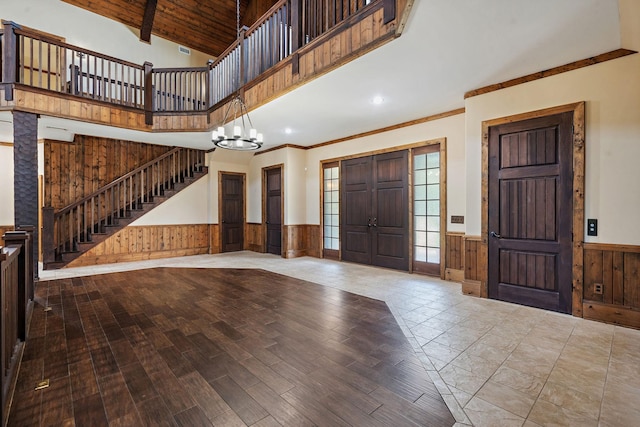 foyer entrance featuring an inviting chandelier, wooden walls, wood ceiling, light hardwood / wood-style floors, and beam ceiling