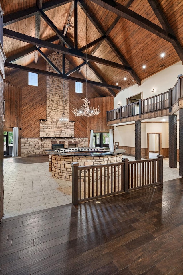 kitchen featuring wood-type flooring, high vaulted ceiling, wooden ceiling, kitchen peninsula, and beam ceiling