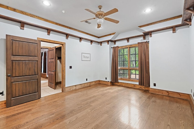 unfurnished room with beamed ceiling, ceiling fan, and light wood-type flooring