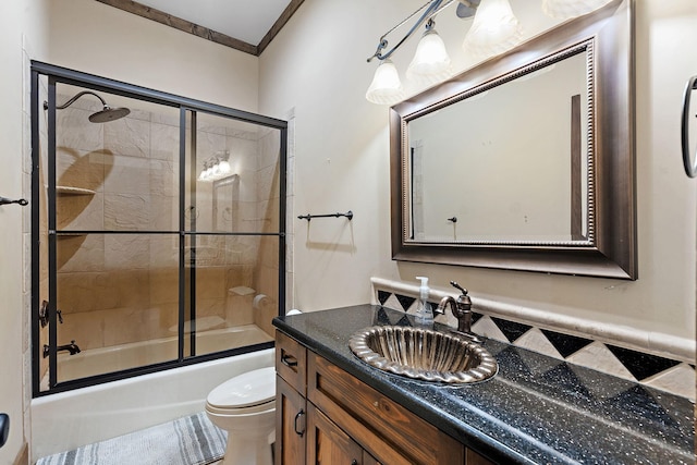 full bathroom featuring toilet, vanity, bath / shower combo with glass door, and crown molding