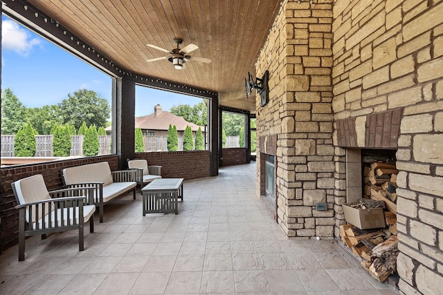 view of patio / terrace with an outdoor living space with a fireplace and ceiling fan