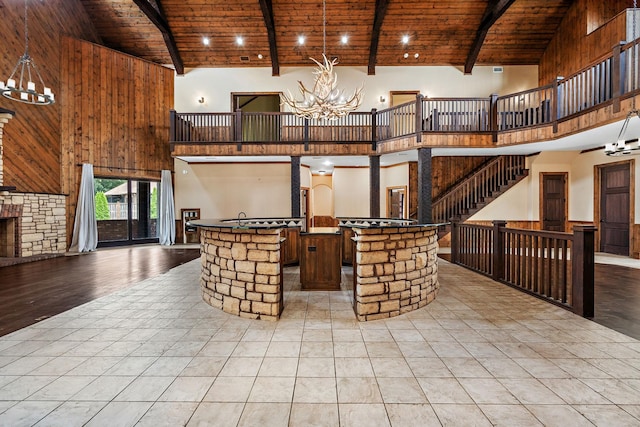 kitchen featuring high vaulted ceiling, beam ceiling, wooden ceiling, and a chandelier