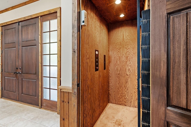 interior space featuring elevator and wooden walls