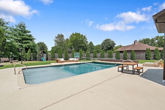 view of pool with a playground and a patio area