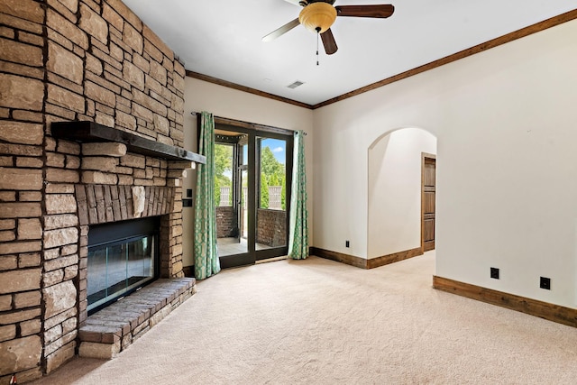 unfurnished living room featuring light carpet, crown molding, a fireplace, and ceiling fan