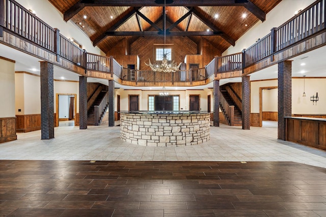 interior space featuring an inviting chandelier, wood-type flooring, high vaulted ceiling, wooden ceiling, and beamed ceiling