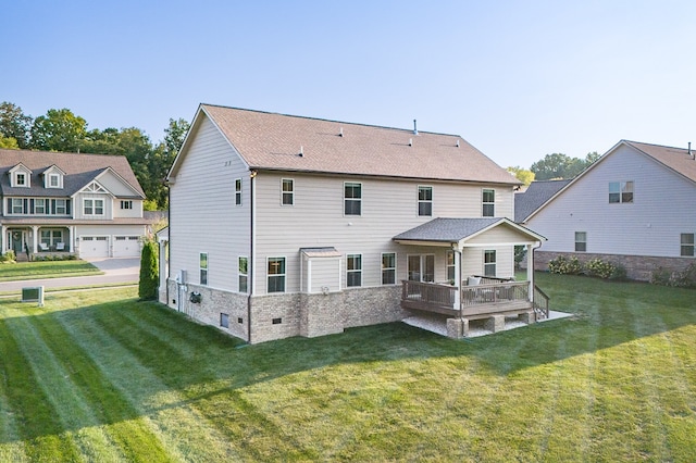 rear view of house featuring a garage and a lawn