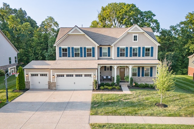 craftsman inspired home with a garage, covered porch, and a front lawn