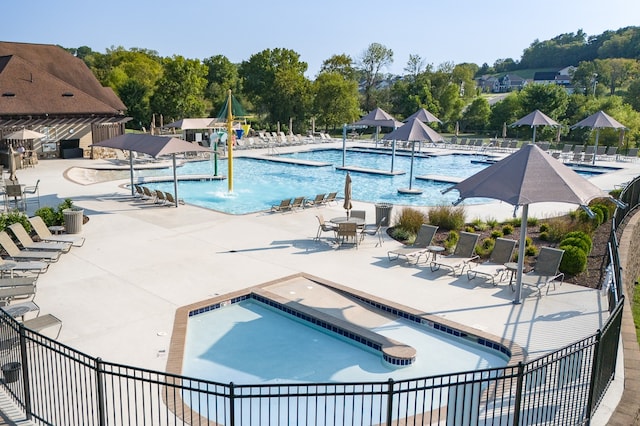 view of pool with pool water feature, a hot tub, and a patio area