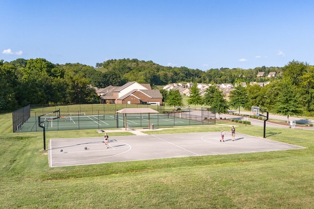 view of sport court with tennis court and a lawn