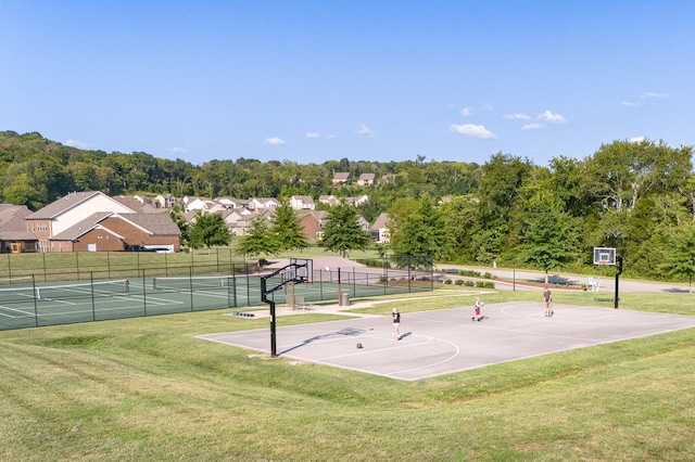 surrounding community with basketball hoop and a lawn