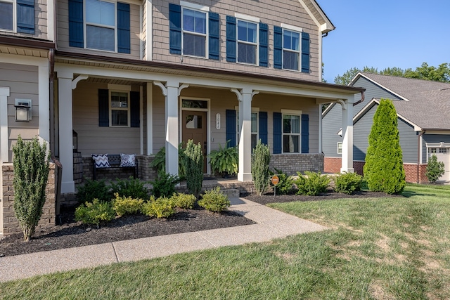 property entrance with covered porch and a lawn