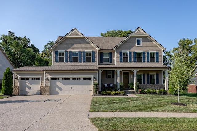 craftsman house with a porch, a garage, and a front yard