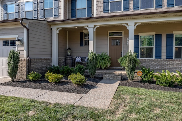 view of exterior entry featuring a porch and a garage