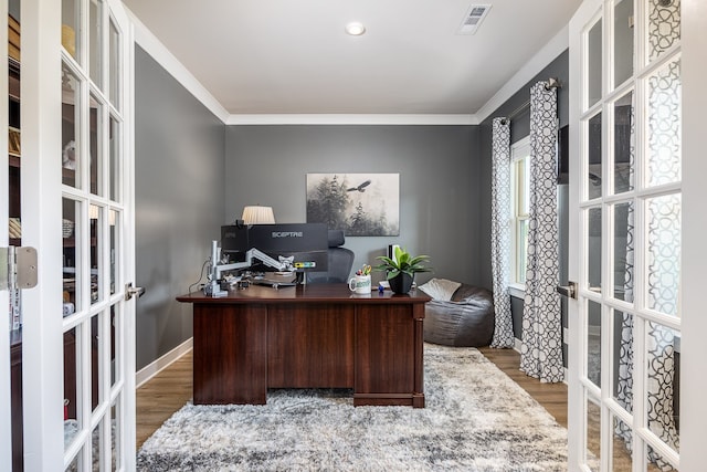 home office with crown molding, french doors, and hardwood / wood-style flooring