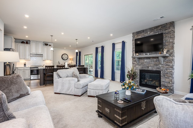 living room with a fireplace and light colored carpet