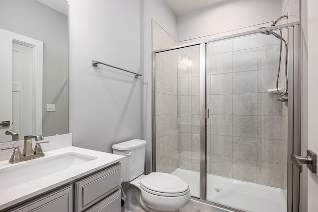 bathroom featuring a shower with door, toilet, and vanity