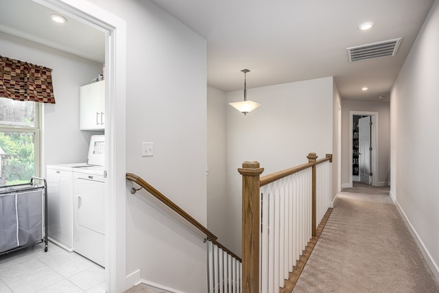 corridor with light carpet and washer and clothes dryer