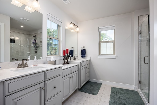 bathroom featuring walk in shower, tile patterned floors, double sink vanity, and plenty of natural light