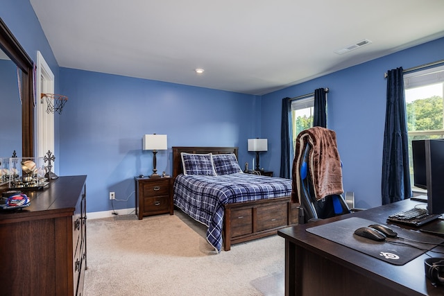 bedroom with multiple windows and light colored carpet