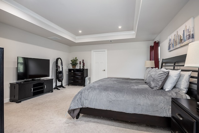 bedroom featuring light carpet and a tray ceiling