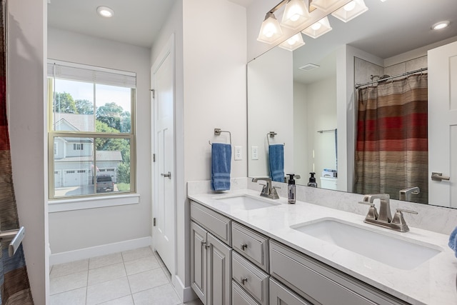 bathroom with tile patterned flooring and dual bowl vanity