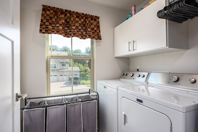 washroom featuring cabinets and washing machine and clothes dryer