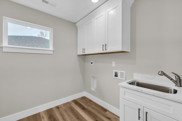 laundry room featuring cabinets, sink, light hardwood / wood-style flooring, washer hookup, and hookup for an electric dryer