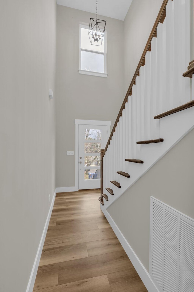 entryway with light wood-type flooring and a notable chandelier