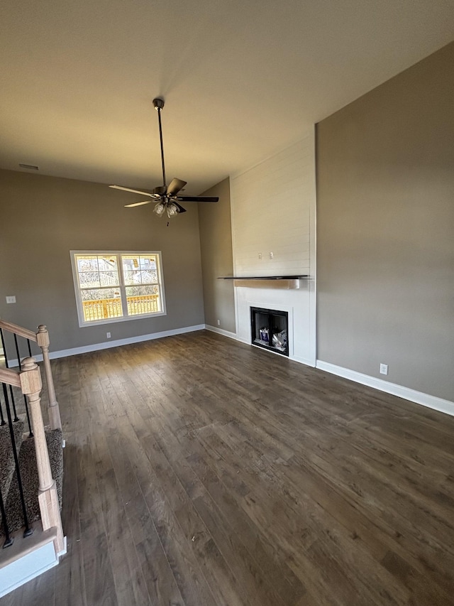 unfurnished living room with dark hardwood / wood-style flooring and ceiling fan