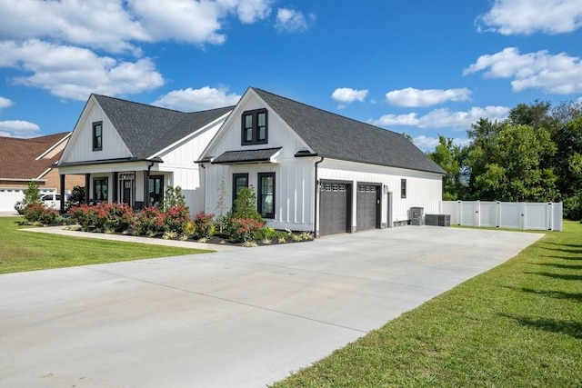 view of front of property featuring a garage, a porch, central AC unit, and a front lawn