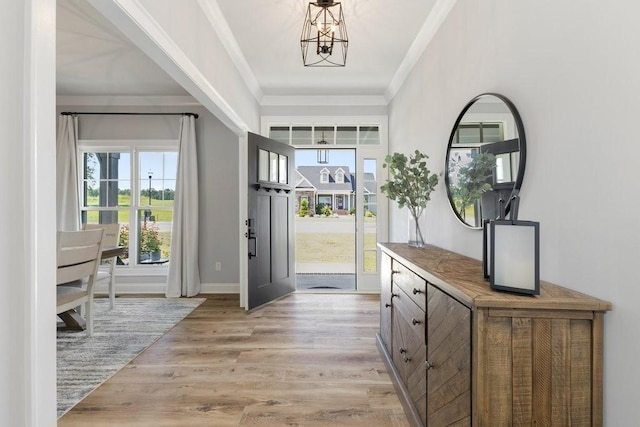 entrance foyer with crown molding, a notable chandelier, and light hardwood / wood-style floors