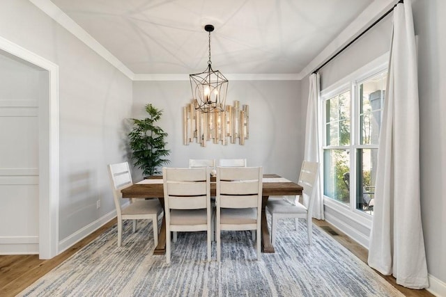 dining area with an inviting chandelier, hardwood / wood-style flooring, and ornamental molding