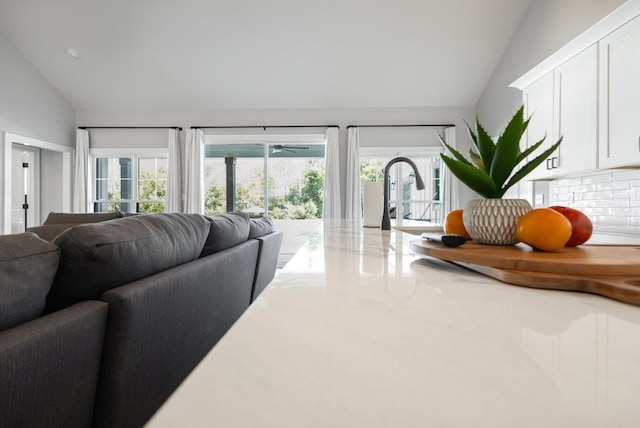 living room with sink, lofted ceiling, and plenty of natural light