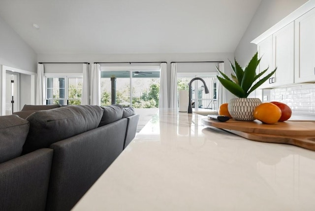 living room featuring lofted ceiling, plenty of natural light, and sink