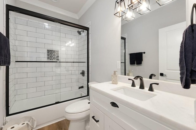 full bathroom featuring crown molding, bath / shower combo with glass door, vanity, wood-type flooring, and toilet