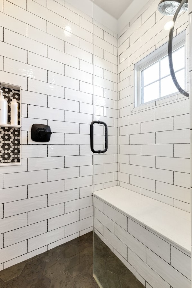 bathroom featuring a tile shower and tile patterned flooring