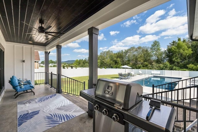 view of patio with a fenced in pool, ceiling fan, an outdoor kitchen, and grilling area