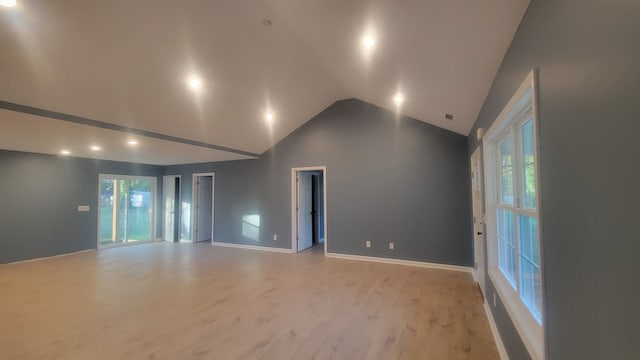 spare room featuring light hardwood / wood-style flooring, high vaulted ceiling, and plenty of natural light