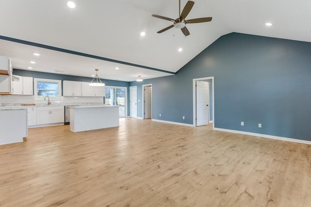 unfurnished living room featuring ceiling fan, plenty of natural light, sink, and light hardwood / wood-style flooring