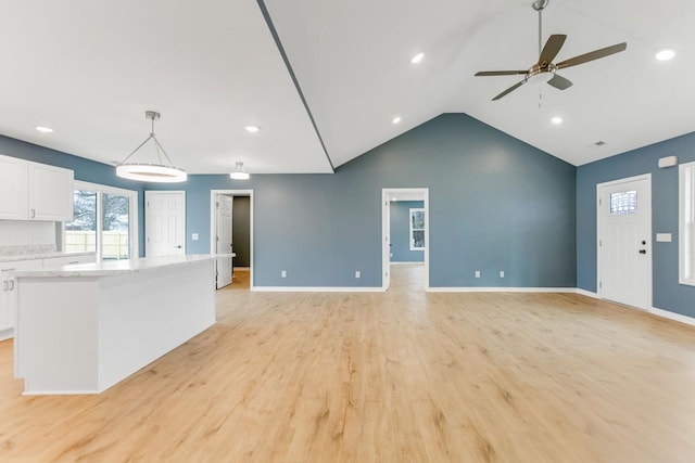 unfurnished living room with ceiling fan, light hardwood / wood-style flooring, and lofted ceiling