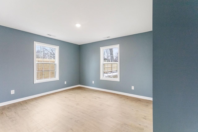 empty room featuring light wood-type flooring and a wealth of natural light