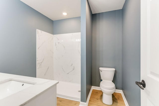 bathroom featuring sink, toilet, hardwood / wood-style flooring, and a shower